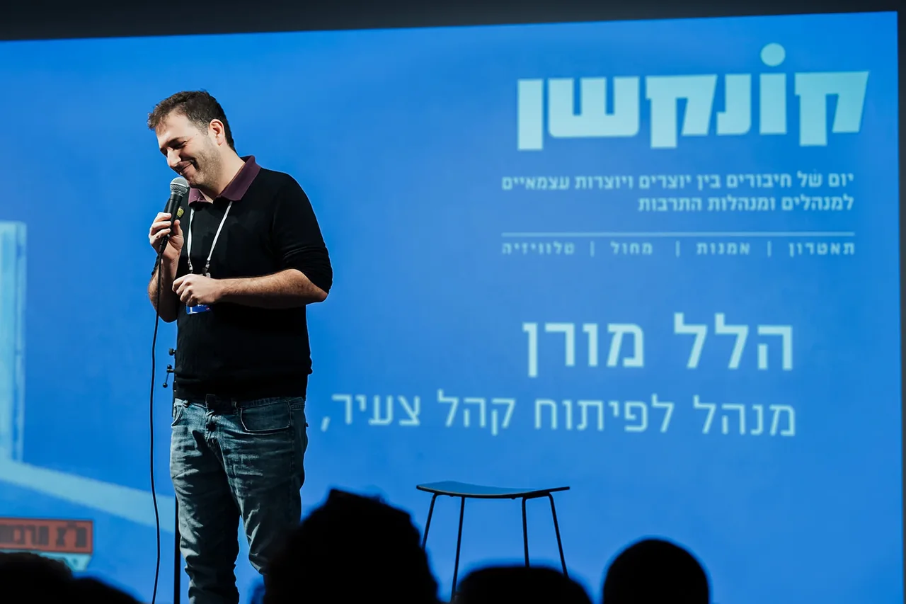 דובר מול מצגת קונקשן בתא תרבות — צילום אמנון חורש