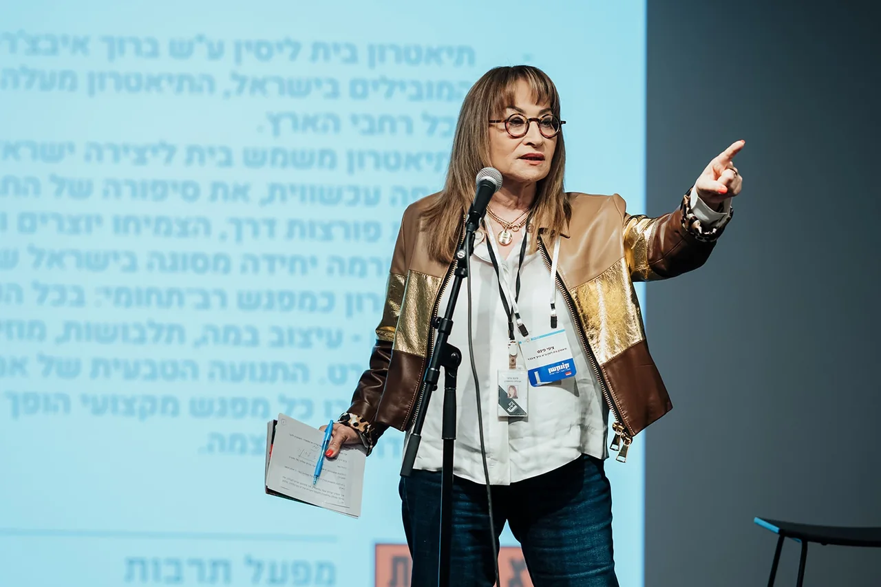 דוברת עם מיקרופון במהלך מושב מקצועי — צילום אמנון חורש