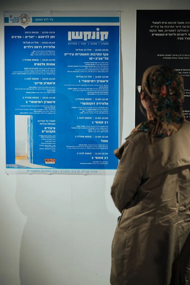 משתתפת בוחנת את תוכנית המושבים בקונקשן — צילום אמנון חורש