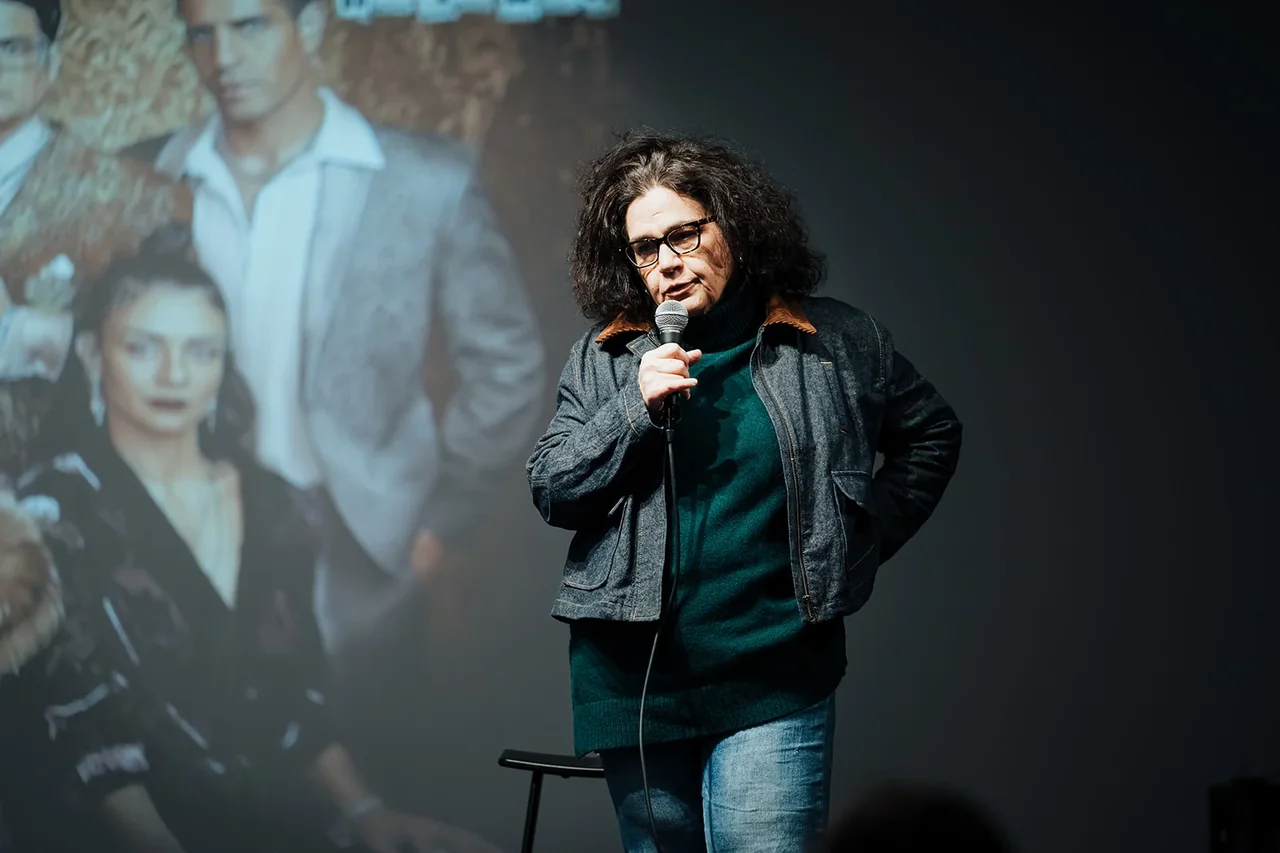 דובר מול מצגת יצירה על המסך — צילום אמנון חורש