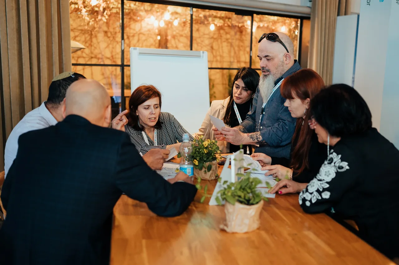 שיחה ועבודה בקבוצה סביב שולחן — צילום אמנון חורש