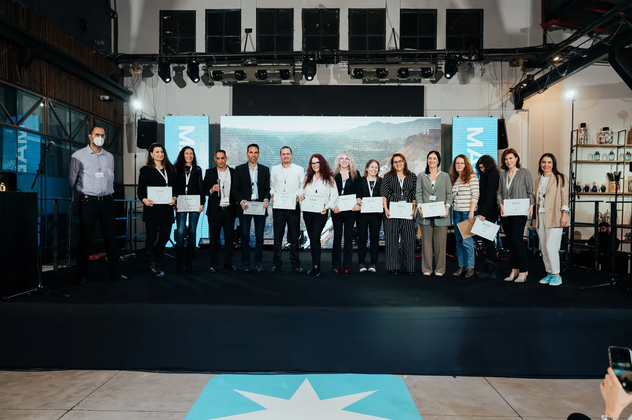 צילום קבוצתי של מקבלי התעודות על הבמה — צילום אמנון חורש